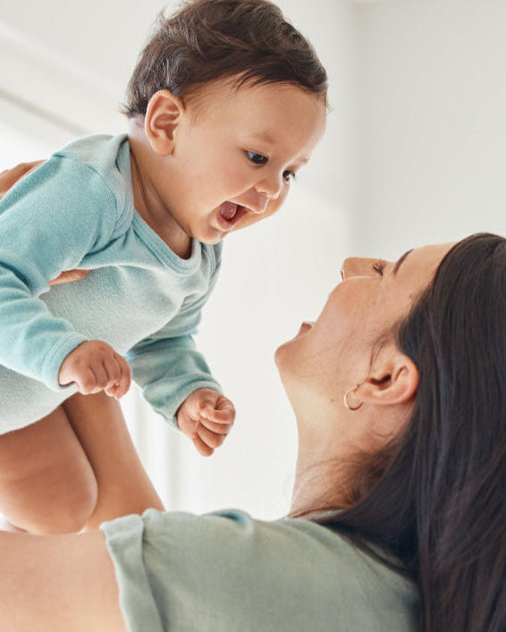 Woman holding a baby in a bright room